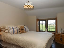 A bedroom with a bed and window at Higher Wadden Farm in Southleigh