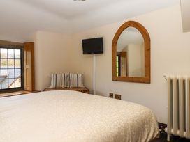 A bedroom with a bed and television at Higher Wadden Farm in Southleigh