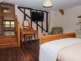 A bedroom with a bed and a mirror at Higher Wadden Farm in Southleigh