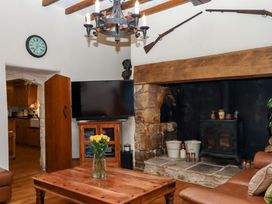 A living room with a fireplace and television at Higher Wadden Farm Southleigh