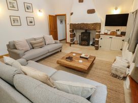 A living room with a fireplace and a coffee table at Riverside Barn in Stithians