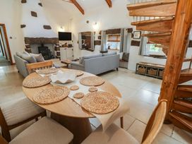 A living room with a dining table and sofa at Riverside Barn in Stithians