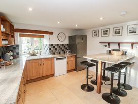 A kitchen with wooden cabinets and a countertop at Riverside Barn in Stithians