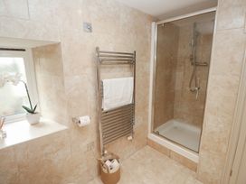A bathroom with a shower and towel rail at Riverside Barn Stithians