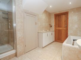 A bathroom with a shower and bathtub at Riverside Barn in Stithians