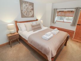 A bedroom with a bed and towels on the covers at Riverside Barn Stithians