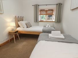 A bedroom with two beds and a window at Riverside Barn in Stithians