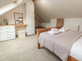 A bedroom with a bed and towels on top at Riverside Barn in Stithians