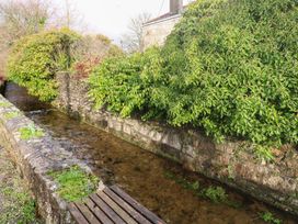 A stream with stone walls and vegetation at Riverside Barn Stithians