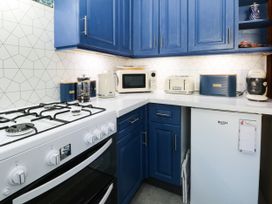 A kitchen with appliances including a gas stove, microwave, and fridge at Ferncliffe