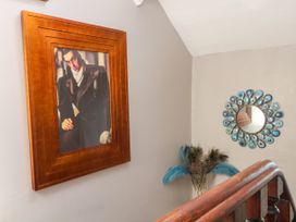 A staircase with a picture frame and a decorative mirror at Ferncliffe