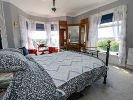 A bedroom with a bed and windows at Ferncliffe