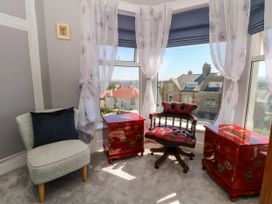 A room with a window, two small tables, and seating at Ferncliffe