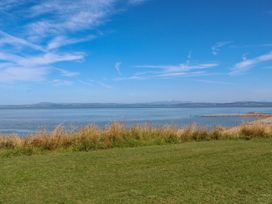 A view of water and grass under a blue sky at Ferncliffe 