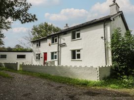 A house with a red door and white fence at Neuadd Wen in Gaerwen