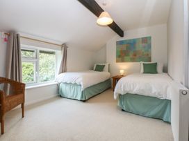 A bedroom with two single beds and a window at Neuadd Wen in Gaerwen