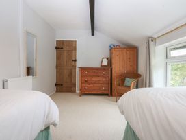 A bedroom with a bed, mirror, and dresser at Neuadd Wen in Gaerwen