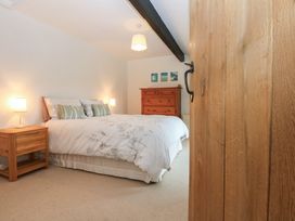 A bedroom with a bed and dresser at Neuadd Wen in Gaerwen
