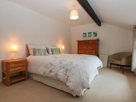 A bedroom with a bed and dresser at Neuadd Wen in Gaerwen