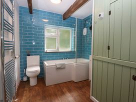 A bathroom with a bathtub and shower at Neuadd Wen Gaerwen
