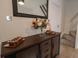 A hallway with a side table and flowers at 23 South Lackenby in Eston