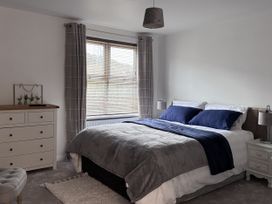 A bedroom with a bed and a dresser at Ironstone Cottage in Eston