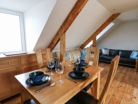 A dining room with a table set for a meal at Awel Deg, Tresaith