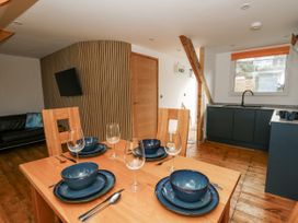 A dining area with a table set for meals at Awel Deg, Tresaith