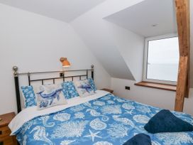 A bedroom with a bed and window at Awel Deg, Tresaith