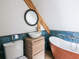 A bathroom with a tub, sink, and toilet at Awel Deg, Tresaith