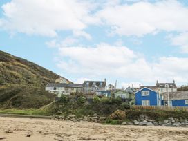 Houses on a hill with sand in foreground at Awel Deg, Tresaith