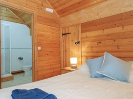 A bedroom with wooden walls and a bed at Pencarrow in St Breward