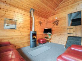 A living room with a fireplace and sofa at Trebah in St Breward
