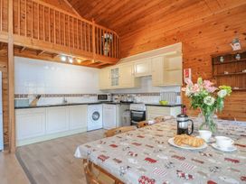 A kitchen with a dining table and appliances at Eden St Breward