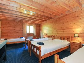 A bedroom with multiple beds and wooden interior at Eden St Breward