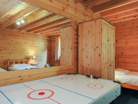 A bedroom with wooden walls and air hockey table at Eden St Breward