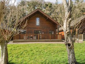 A log cabin with a deck and grass area at Heligan in St Breward
