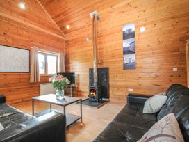 A living room with a fireplace and television at Heligan in St Breward