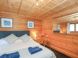 A bedroom with a bed and wooden decor at Heligan St Breward