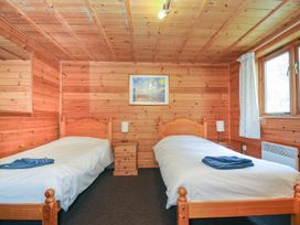 A bedroom with two beds and a nightstand at Heligan St Breward