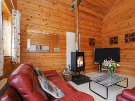 A living room with a fireplace and sofa at Polzeath in St Breward