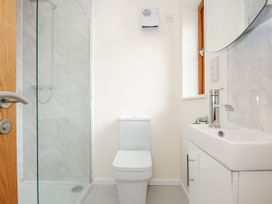 A bathroom with a shower, toilet, and sink at Polzeath in St Breward