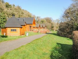 Log cabins and pathway surrounded by trees at Polzeath in St Breward