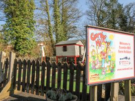 An outdoor area with a playhouse and a sign at Coombe Mill in St Breward
