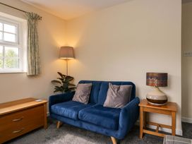 A living room with a blue sofa and a lamp at Buckbarrow in Seascale