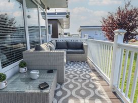 An outdoor patio with a couch and table at 3 Cherry Blossom in Skegness