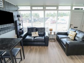 A living room with two sofas and a table at 3 Cherry Blossom in Skegness