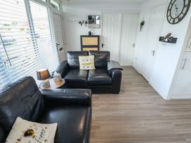 A living room with a sofa and lamp at 3 Cherry Blossom in Skegness
