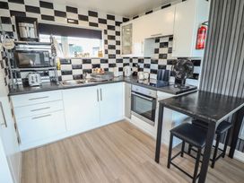 A kitchen with appliances and dining table at 3 Cherry Blossom in Skegness