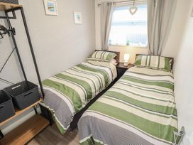 A bedroom with two beds and a lamp at 3 Cherry Blossom in Skegness